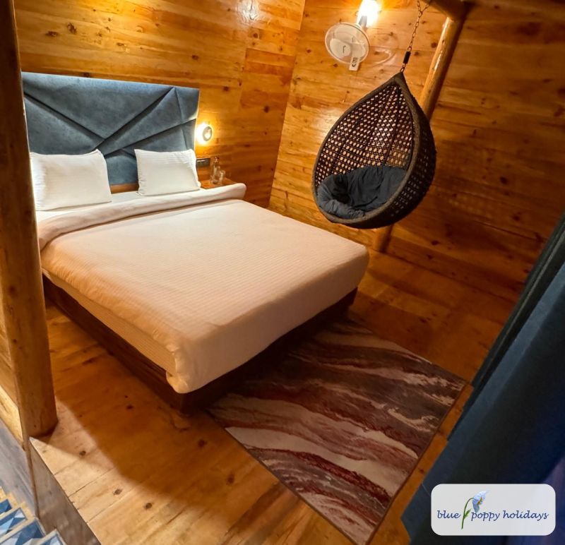 A wood-lined room with a hanging chair at Blue Poppy Premier